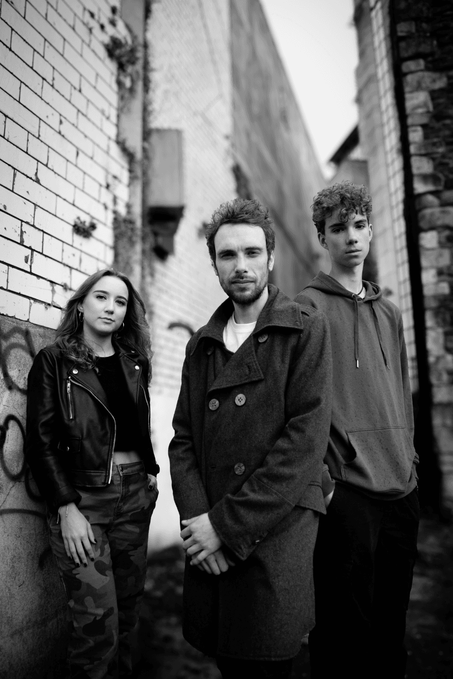 Black and white band promotional photograph in an alley